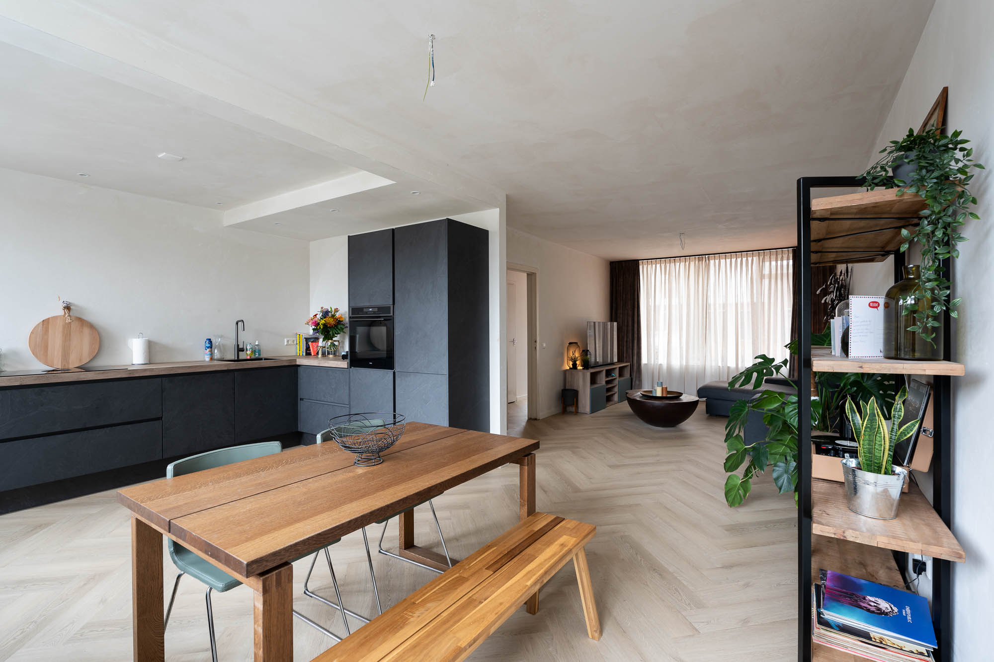 Open woonkamer met moderne keuken en vernieuwde vloer