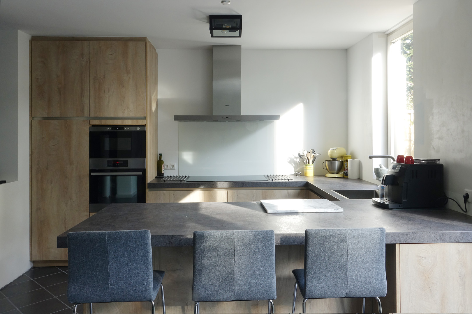 Moderne keuken met houten kasten en kookeiland na renovatie